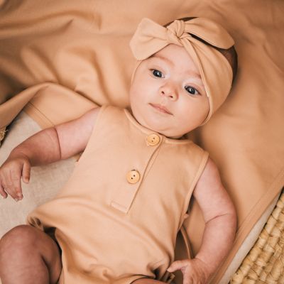 Baby in ledikant met kleertjes van UAUA